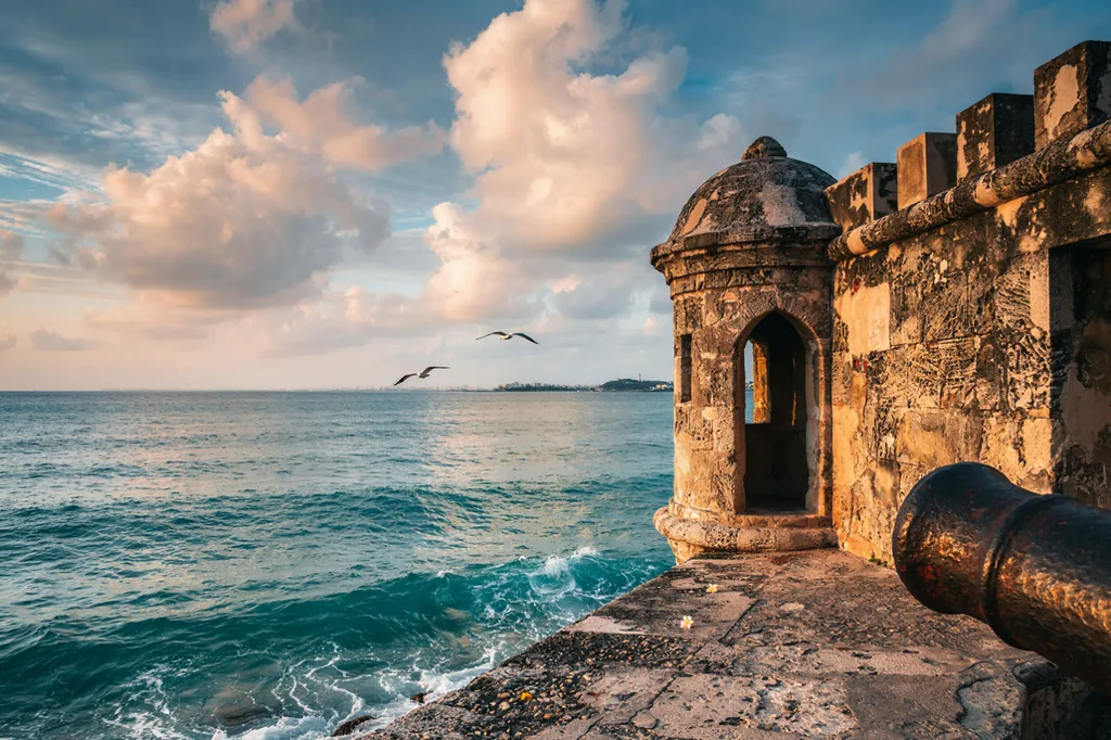 Una garita de piedra en la muralla de El Morro, con el Atlántico al fondo.